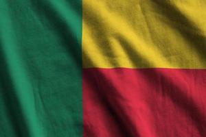 Benin flag with big folds waving close up under the studio light indoors. The official symbols and colors in banner photo