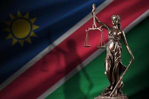 Namibia flag with statue of lady justice and judicial scales in dark room. Concept of judgement and punishment photo