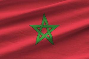 Morocco flag with big folds waving close up under the studio light indoors. The official symbols and colors in banner photo