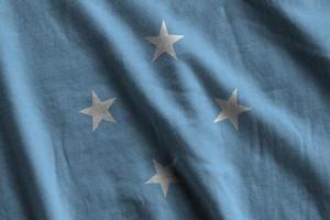 Micronesia flag with big folds waving close up under the studio light indoors. The official symbols and colors in banner photo