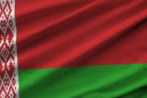 Belarus flag with big folds waving close up under the studio light indoors. The official symbols and colors in banner photo