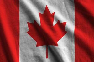 Canada flag with big folds waving close up under the studio light indoors. The official symbols and colors in banner photo