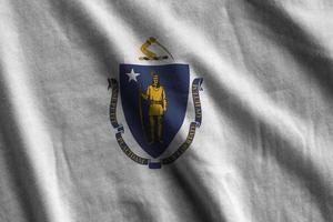 Massachusetts US state flag with big folds waving close up under the studio light indoors. The official symbols and colors in banner photo