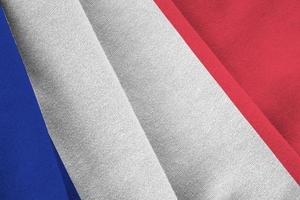 France flag with big folds waving close up under the studio light indoors. The official symbols and colors in banner photo