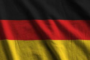 Germany flag with big folds waving close up under the studio light indoors. The official symbols and colors in banner photo