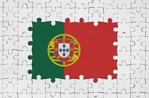 Portugal flag in frame of white puzzle pieces with missing central part photo