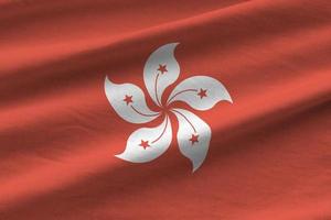 bandera de hong kong con grandes pliegues ondeando de cerca bajo la luz del estudio en el interior. los símbolos y colores oficiales en banner foto