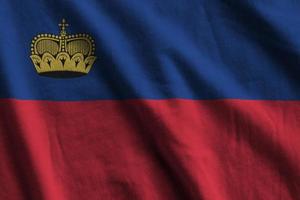 Liechtenstein flag with big folds waving close up under the studio light indoors. The official symbols and colors in banner photo