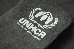 Kyiv, ucrania - 4 de mayo de 2022 acnur el logotipo de la agencia de refugiados de la onu en mantas grises humanitarias foto