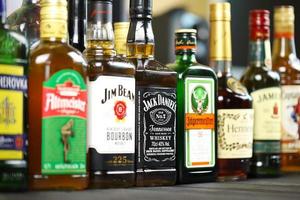 KYIV, UKRAINE - MAY 4, 2022 Many new bottles of worldwide popular alcohol brands of whiskey cognac photo