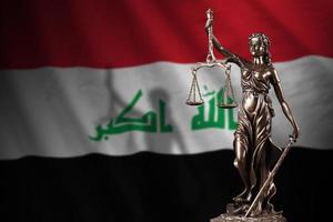 Iraq flag with statue of lady justice and judicial scales in dark room. Concept of judgement and punishment photo