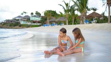 Entzückende kleine Mädchen, die mit Sand am Strand spielen. video