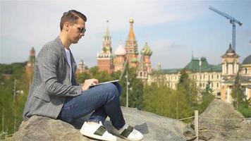 Man is working by laptop while relaxing in the park video