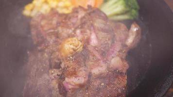 close up cooked of delicious sirloin steak served on a hot pan plate with roasted vegetable and many smoke from plate video