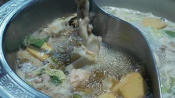 blick auf kochenden heißen topf lecker mit würziger suppe shabu shabu im chinesischen stil mit gemüse im topf video