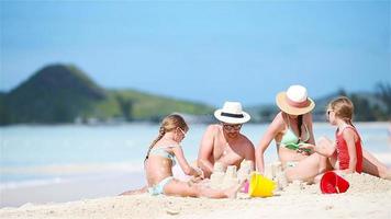 familj framställning sand slott och njuter högtider på tropisk vit strand video