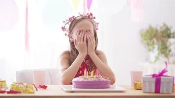 Kaukasisches Mädchen trägt an ihrem Geburtstag eine Maske. festlicher bunter hintergrund mit luftballons. geburtstagsfeier und wunschkonzept. video