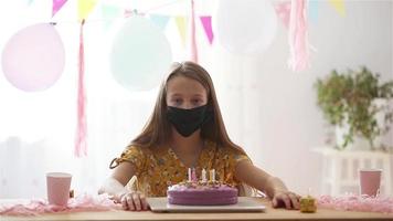 kaukasisch Mädchen enttäuschend auf ihr Geburtstag. festlich bunt Hintergrund mit Luftballons. Geburtstag Party und wünscht sich Konzept. video