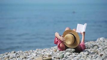 mujer joven leyendo un libro durante la playa blanca tropical video
