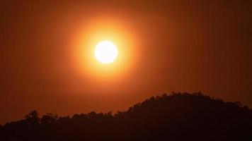 zonsondergang over- een berg in de oranje lucht 4k tijd vervallen video. video