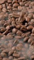 Vertical slow motion of roasted coffee beans falling. Organic coffee seeds. video