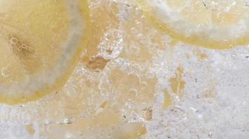 Soda water with ice cubes and sliced lemon slow motion video. video