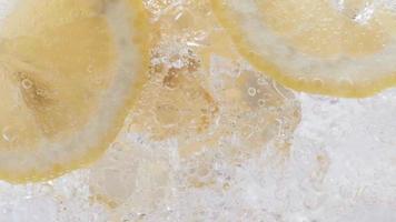 Soda water with ice cubes and sliced lemon slow motion video. video