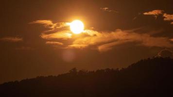 puesta de sol sobre una montaña en el cielo naranja 4k video de lapso de tiempo.