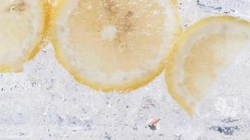 Soda water with ice cubes and sliced lemon slow motion video. video