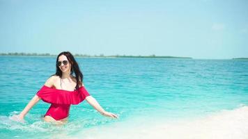 contento hermosa mujer tener divertido en tropical costa. joven niña disfrutar su tropical vacaciones exótico isla video