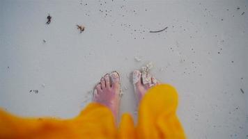 Vacation on ocean beach, feet on sea sand. Close up of female feet on white sandy beach video