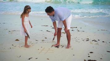 padre y pequeño niña a tropical playa video