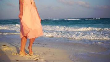 schön jung Frau auf Sommer- Ferien auf Weiß Strand. Nahansicht weiblich Beine auf das Strand im das Sonnenuntergang video