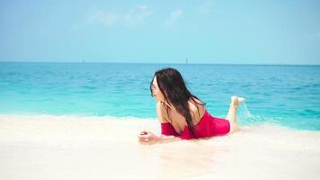 Young beautiful woman lying at shallow tropical water video