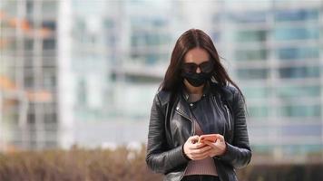 vrouw vervelend een masker Aan een achtergrond van een modern gebouw, video