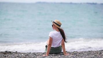 mujer tendida en la playa disfrutando de las vacaciones de verano mirando al mar video