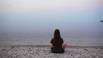 Little girl at tropical beach in yoga video