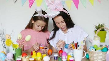 moeder en haar weinig dochter schilderij eieren. gelukkig familie voorbereidingen treffen voor Pasen.