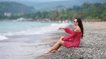 kvinna om på de strand njuter sommar högtider ser på de hav video
