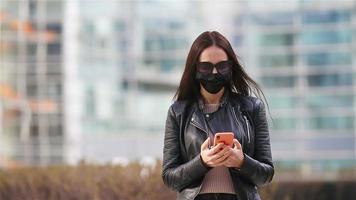 Woman wearing a mask on a background of a modern building, video