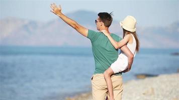 poco ragazza e contento papà avendo divertimento durante spiaggia vacanza video