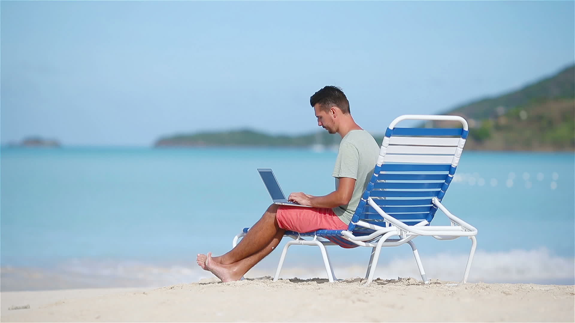 Young man with laptop on tropical caribbean beach. Man sitting on the ...