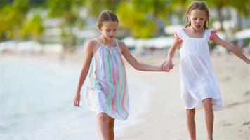 weinig meisjes hebben pret Bij tropisch strand gedurende zomer vakantie spelen samen video