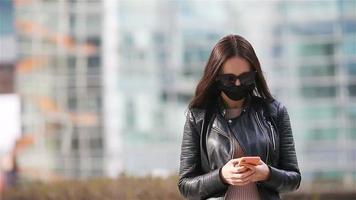 Woman wearing a mask on a background of a modern building, video