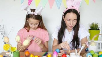 mor och henne liten dotter målning ägg. Lycklig familj framställning för påsk. video