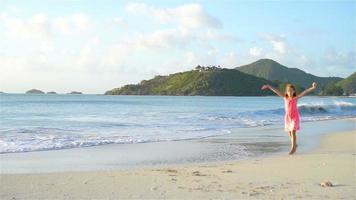 Adorable little girl on the beach having fun. SLOW MOTION video