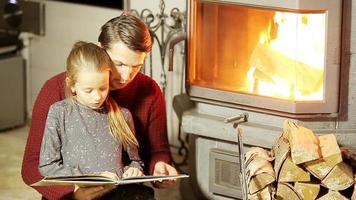 Family sitting by a fireplace in their family home on Christmas video