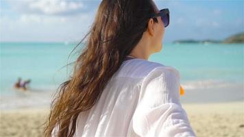 Back view of young woman on tropical white beach. SLOW MOTION video