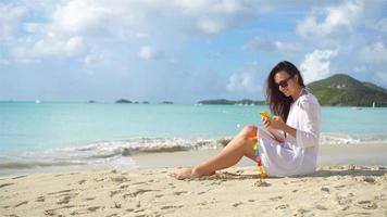 jong vrouw met smartphone gedurende tropisch strand vakantie. mooi meisje Aan de strand met mobiele telefoon Aan caraïben eiland. video