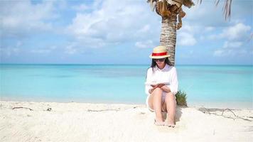 Young woman reading book during tropical white beach video